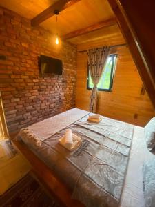 a large bed in a wooden room with a window at Wood & Bricks Chalet in Giuleşti +16 photos