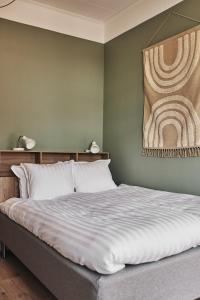 een slaapkamer met een bed met een schilderij aan de muur bij Hotell Slottsgatan in Oskarshamn