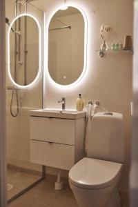 y baño con aseo, lavabo y espejo. en Hotell Slottsgatan en Oskarshamn