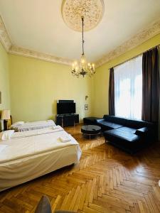 a bedroom with a bed and a couch and a chandelier at Main Market Square Apartments in Krakow