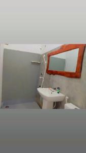 een badkamer met een wastafel en een spiegel bij Sanity Door Rooms and Hostel in Arugam Bay