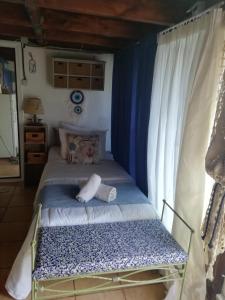 a bed in a room with a blue and white canopy at Kynosoura's sea view in Ambelákia