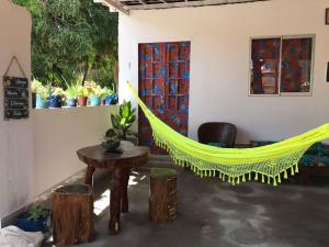 a hammock in a room with a table and chairs at Cantinho da mery 1 in Maragogi