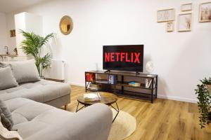 a living room with a couch and a tv at IDEE Living: Modernes City-Apartment mit Altbaucharme in Weinheim