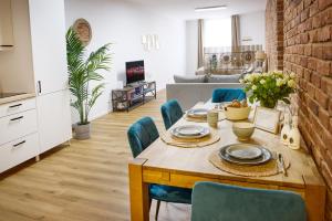 eine Küche und ein Wohnzimmer mit einem Holztisch und Stühlen in der Unterkunft IDEE Living: Modernes City-Apartment mit Altbaucharme in Weinheim