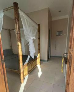 een slaapkamer met een houten bed met een hemelbed bij Mangoverde Guesthouse in Moalboal