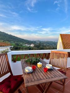 a wooden table on a balcony with two chairs at Casa da Boavista in Arraiolos