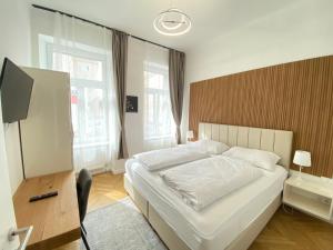 a bedroom with a large white bed and a desk at Vienna Stay Apartments or Rooms 1050 in Vienna