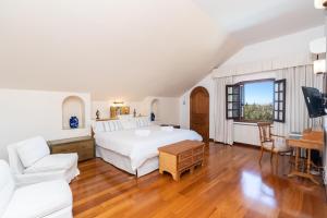 a bedroom with a white bed and a living room at Casa El Maizal in Marbella