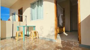 een tafel en twee krukken voor een huis bij Mangoverde Guesthouse in Moalboal