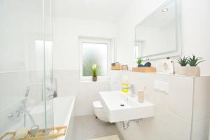 a white bathroom with a sink and a mirror at RT03-FW Wohnung in Schwanstetten in Schwanstetten +32 photos