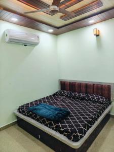 a large bed in a room with a fan at Mahakal Homestay in Ujjain