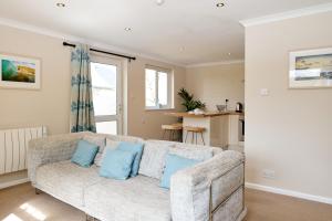a living room with a couch with blue pillows at Gwithian Holidays in Hayle