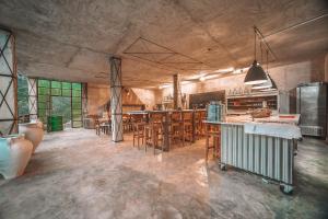 cocina grande con mesas y sillas de madera en Eco Hotel Cueva del Gato, en Benaoján