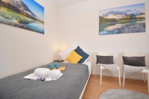 1 dormitorio con 1 cama con 2 sillas en RT03-FW Wohnung in Schwanstetten, en Schwanstetten