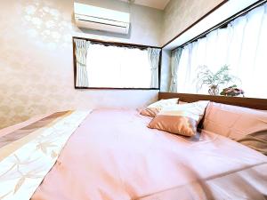 1 cama grande en un dormitorio con ventana en Shinjuku/Okubo sta, 3 min walk/switch/board game/65㎡２LDK, en Tokio