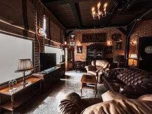 a living room with leather furniture and a brick wall at Letana Hotel in Bang Phli
