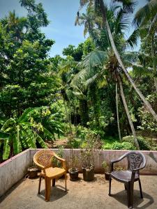 two chairs and a table on a patio at Rams Gratitude Inn in Varkala