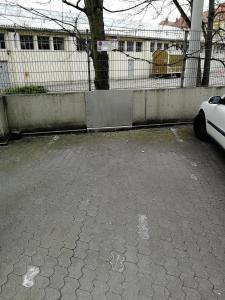 a car parked in a parking lot next to a fence at HOG Apartment Nürnberg St. Peter in Nuremberg