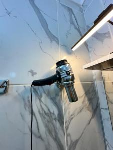uma cabeça de chuveiro ligada a uma cabina de duche em vidro em pilot hotel em Arnavutköy