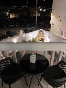 stół i 2 krzesła na balkonie z deską surfingową w obiekcie AnnaMaria Pansion w mieście Naksos
