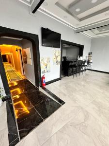 a large room with a black marble floor and a television at pilot hotel in Arnavutköy