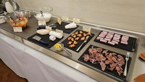 a table with meat and other food items on it at Hotel Burrhus in Vaison-la-Romaine