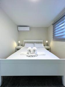 um quarto com uma cama branca e toalhas em פנטהאוז השומר em Tiberias