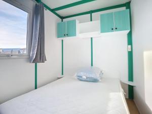 1 dormitorio con 1 cama con armarios azules y ventana en chalet calme, en Givrand