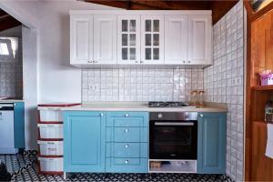 a kitchen with blue cabinets and a stove top oven at CARETTA PANSİYOn in Kas +79 photos
