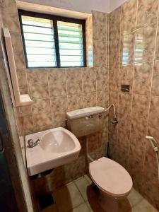 a bathroom with a toilet and a sink at Rams Gratitude Inn in Varkala