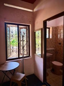 a bathroom with a window and a sink and a toilet at Rams Gratitude Inn in Varkala