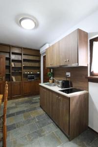 a large kitchen with wooden cabinets and a sink at Raise Polydrosos Traditional Getaway in Polydrossos