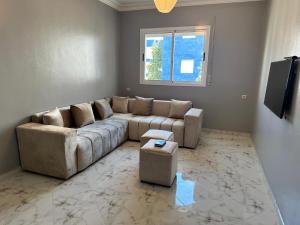 un soggiorno con un divano e una finestra di Modern beach appartment in the heart of Martil a Martil