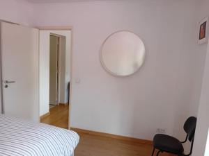 sypialnia z krzesłem i lustrem na ścianie w obiekcie Sunny Two Bedroom Apartment w Lizbonie