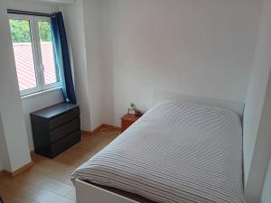 niewielka sypialnia z łóżkiem i oknem w obiekcie Sunny Two Bedroom Apartment w Lizbonie