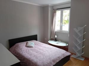 sypialnia z łóżkiem, stołem i oknem w obiekcie Sunny Two Bedroom Apartment w Lizbonie