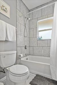 a bathroom with a toilet and a tub and a shower at PetFriendly 2BR Convenient to Stadium&Downtown - ctd in Indianapolis