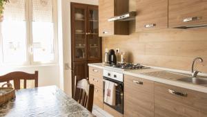 una cucina con armadi in legno e un tavolo con lavandino di Guest House Nonna Angela a Napoli