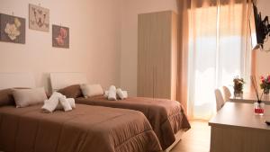 una camera da letto con due letti, un tavolo e una finestra di Guest House Nonna Angela a Napoli