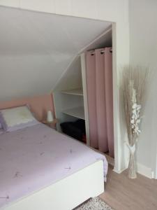 um quarto com uma cama roxa e uma prateleira em MAISON DES LILAS em Bellerive-sur-Allier