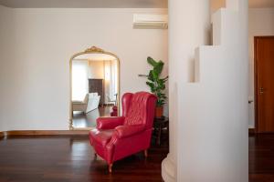 - Silla roja en la sala de estar con espejo en Porta Nuova Home Ravenna, en Rávena