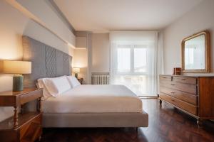 a bedroom with a bed and a mirror and a dresser at Porta Nuova Home Ravenna in Ravenna