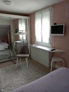 a bedroom with a desk with a computer and a chair at MAISON DES LILAS in Bellerive-sur-Allier