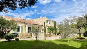 a house with a yard with green grass at Domaine Au Coeur des Alpilles in Maussane-les-Alpilles