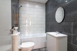 uma casa de banho com um WC, um lavatório e uma banheira em Gorgeous Loft Room em Beckenham