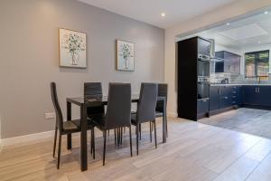 een eetkamer met een zwarte tafel en zwarte stoelen bij Gorgeous Loft Room in Beckenham +7 foto's