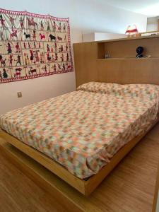 a bed in a bedroom with a blanket on it at Alloggio a picco sul mare in Grimaldi