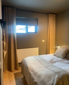un dormitorio con una cama y una ventana en AK-Lux101, en Akureyri