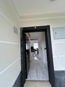 um corredor que leva a um quarto com uma porta preta em Villa Zengin em Kemer